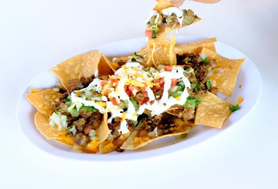 Super Nachos · choice of meat
 beans, cheese, guacamole sauce, sour cream, onions cilantro and tomatoes.