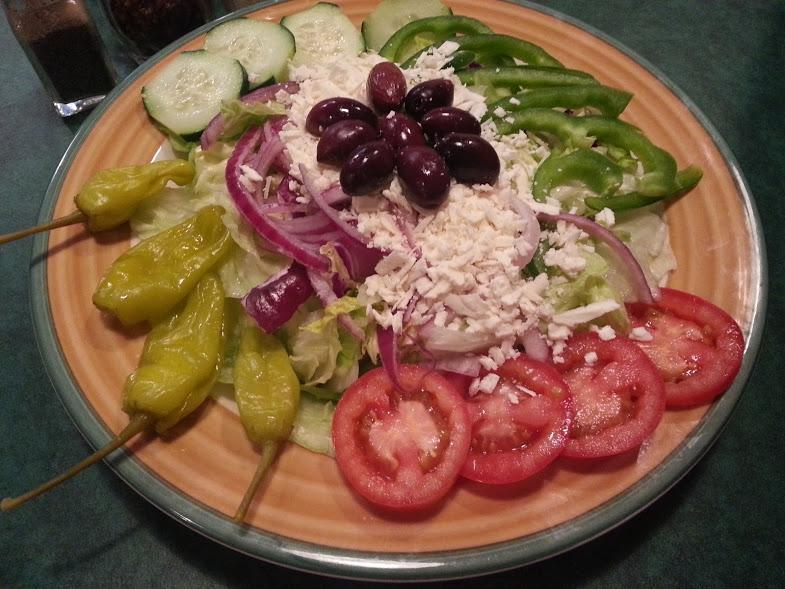 Greek Salad · Mixed greens, tomatoes, cucumber, onions, green peppers, Greek olives, pepperoncini and our homemade Italian dressing.