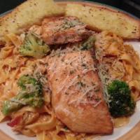 Salmon Fettuccini · Fresh baked salmon served on the top of fettuccini, artichoke hearts, broccoli and capers in...