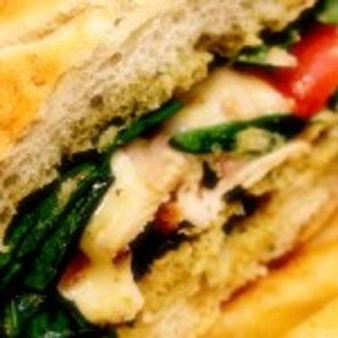Chicken Pesto Sandwich · Toasted ciabatta, pesto cream sauce, spinach, chicken, red onion, tomatoes, and provolone cheese. Served with a pickle and potato chips.