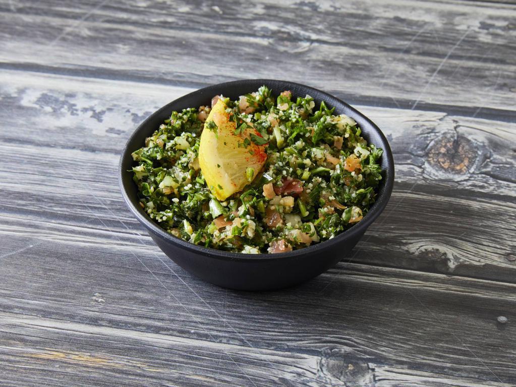 Tabouleh · Cracked wheat, minced tomatoes, fine chopped parsley, and dried mint salad topped with olive oil and lemon.