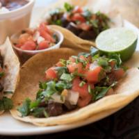 Grilled Steak Tacos · 3 soft corn tortillas filled with grilled steak, onion, pico de gallo and cilantro with rice...