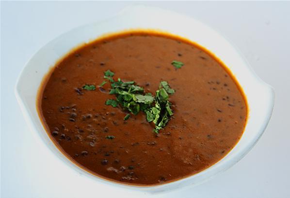 Daal Makhani · Black lentils slowly simmered with traditional spices, a specialty of the Northwest Indian frontier. Accompanied with saffron rice. Gluten free.