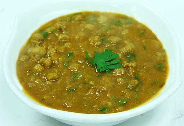 Chana Masala · North Indian specialty of slowly simmered chickpeas with tomatoes, onions, roasted garlic and laced with exotic spices. Gluten free and vegan.