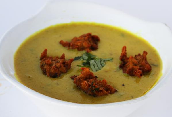 Yogurt Masala · Kadi. A spicy tangy yogurt curry simmered with vegetable fritters.