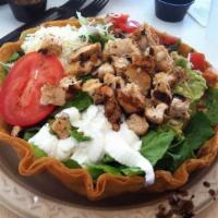 Tostada Salad · Crispy flour tortilla shell filled with romaine, black or pinto beans, guacamole, cheese, pi...
