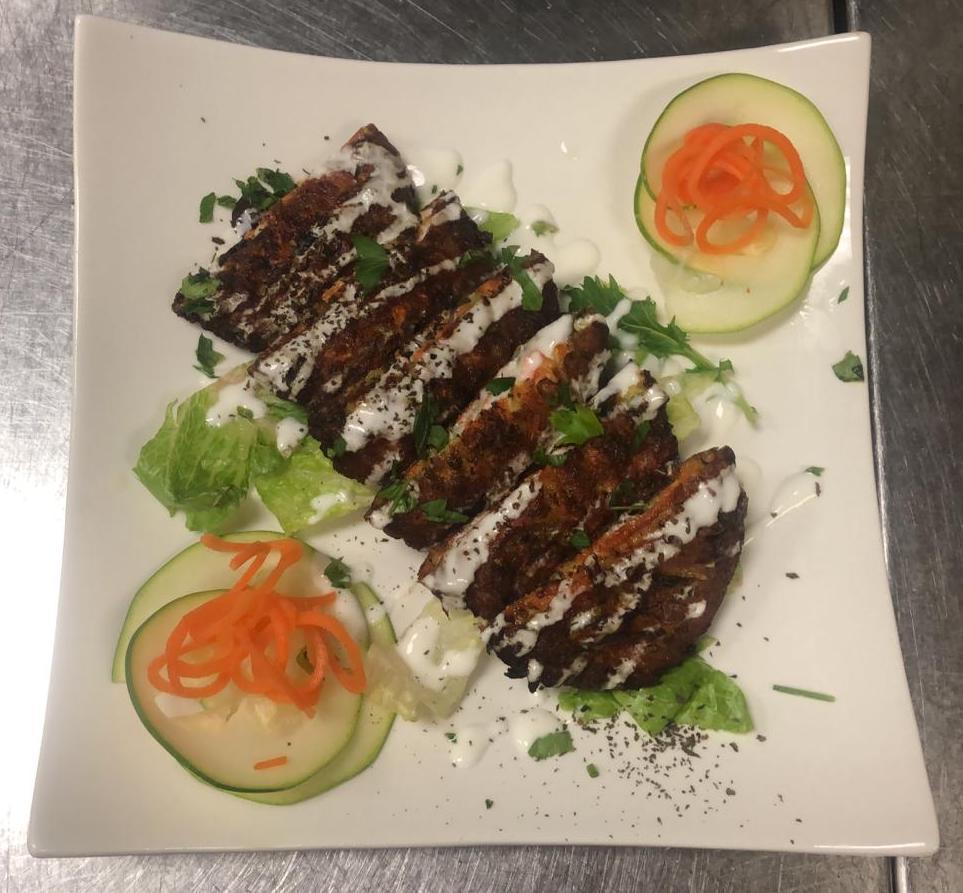 Zucchini Pancakes · Fried zucchini mixed with carrots, onions and feta cheese, drizzled with tzatziki sauce.