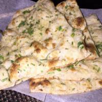 Garlic Naan · Bread topped with fresh garlic, coriander leaves and roasted in the tandoori clay oven. 