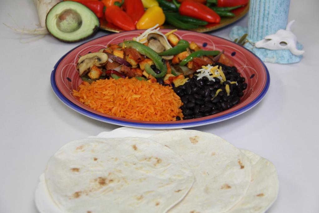 Fajita Platter · Charbroiled chicken or steak on a plate with sauteed mushrooms, bell peppers, tomatoes and onions, rice, beans with cheese on the side with flour or corn tortilla.