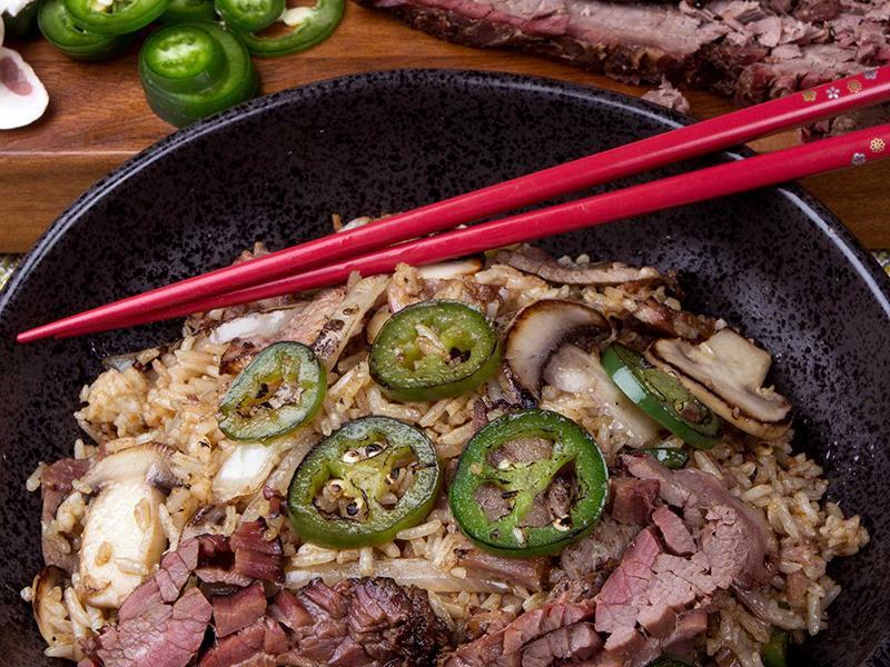 Brisket Jalapeno Fried Rice · Fried rice mixed with smoked brisket, charred onions, jalapenos and mushrooms. Spiced up with Cholula® green pepper sauce. Add a fried egg for $1