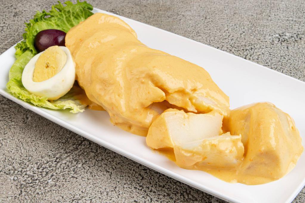 Papa a la Huancaina · Steamed potatoes smothered in our yellow creamy cheese sauce slightly spiced with a hint of Aji Amarillo.