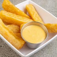 Yuca a La Huancaina · Crispy fried cassava sticks with a side of yellow creamy cheese sauce; slightly spiced with ...