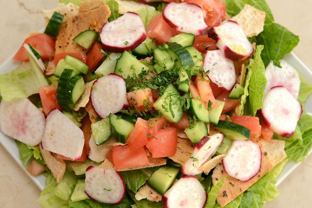 Fattoush Salad · Romaine lettuce, tomatoes, onions, radishes, cucumbers and parsley tossed in our fattoush dressing and topped with pita chips. Vegetarian.
