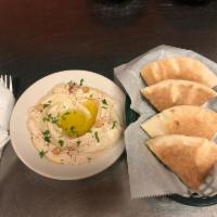 Hummus · A blend of ground chickpeas and tahini, topped with olive oil and spices. Served with pita b...