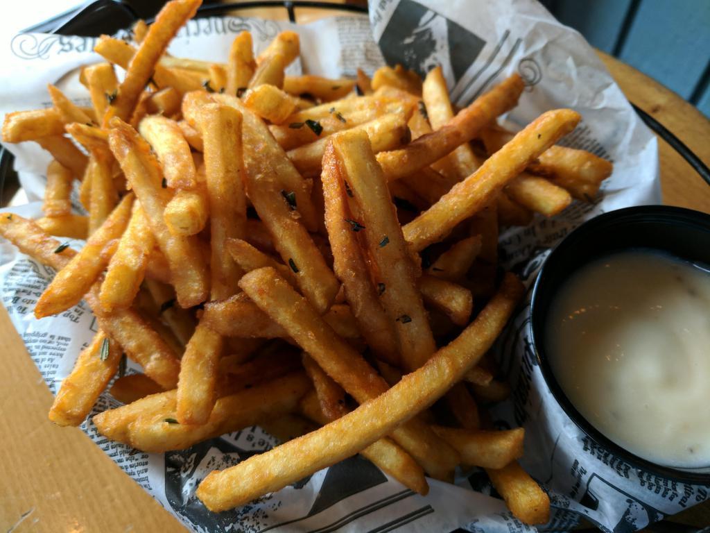 Rosemary Truffle Fries (V, GF) · Salt and pepper seasoned fries tossed in truffle oil topped with fresh rosemary and served with lemon honey aioli