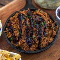 House Smoked Pulled Pork · Cooked in our special blackberry ancho sauce. Served with house Mac and cheese, homemade col...