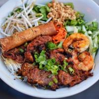 B6. Bun Tom Thit Nuong Cha Gio (Grilled pork, shrimp & an egg roll) · Grilled pork, shrimp and egg roll over vermicelli, lettuce, bean sprouts, chopped cucumber, ...