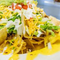 Tortilla Chips Nacho Macho · Topped with ground beef, lettuce, tomato, onions, olives, queso dip, sour cream and grated c...