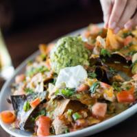 Chicken Nachos · Beans, cheese, red & green sauce, tomato, cilantro, onions, guacamole, sour cream.