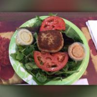 Vegan Crab Cake Passion · Vegan crab cake served with fresh spring mix greens, ripe tomatoes and our famous house garl...