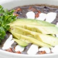 Sopa de Frijol con Chorizo · Chorizo and black bean soup topped with sour cream and avocado.