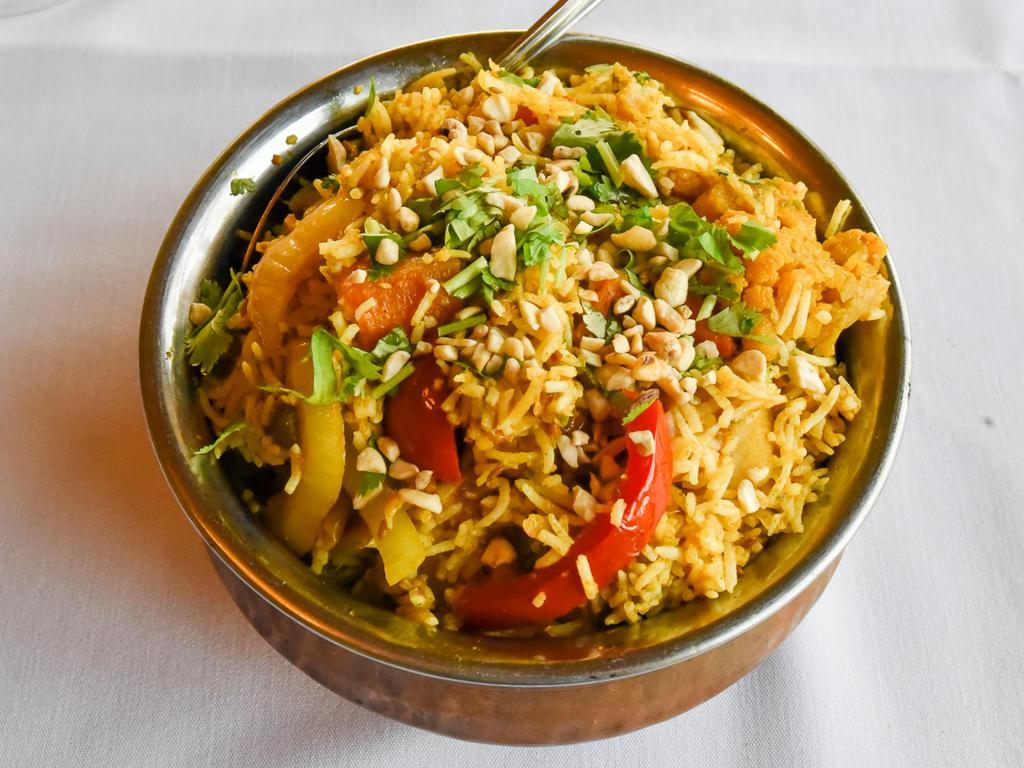 Vegetable Biryani · Basmati rice cooked with fresh vegetables, saffron and mild spices and is garnished with raisins and cashews. Served with raita.
