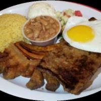 Tipico Montanero · Carne asada, fried egg, chicharron, fried plantain, rice, beans, potato salad, and cucumber ...