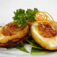 Caramelized Eggs · Eggs with golden yolk covered with caramelized sauce, topped with dried onion, and cilantro
...
