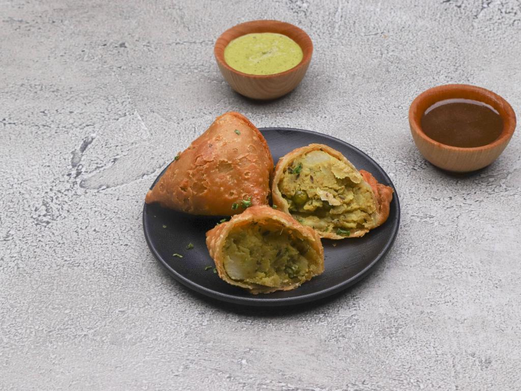 Vegetable Samosa · Crisp pastry stuffed with spiced peas and potatoes.