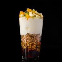Granola Celebration · Granola topped with yogurt, tropical fruits and maple syrup.