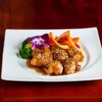 Orange Chicken · Crispy chicken tenders with home-style orange sauce, served with broccoli and carrots.