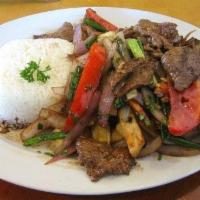 Lomo Saltado Peruano · Strips of sirloin marinated in vinegar, soy sauce and spices, then stir fried with onions, p...