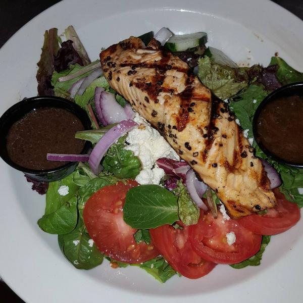 Salmon on the Green Salad · Salmon crusted in peppercorn and seared, served on top of mixed greens, fresh tomatoes, cucumbers, red onions and feta cheese with balsamic vinaigrette.
