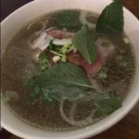 P2. Pho Tai · Beef broth soup with eye round steak. Served with bean sprouts, basil and lime in beef bone ...