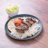 11. Beef Shish Kabob · Marinated slices of flap steak served with basmati rice, green salad, broiled tomato, sliced...