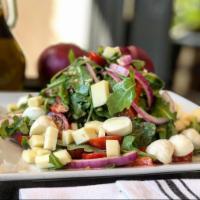Positano Salad · Arugula, tomatoes, roasted peppers, red onions, Asiago cheese and fresh mozzarella cheese wi...