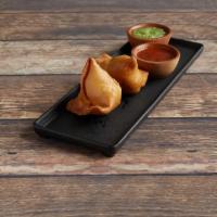 VEGETABLE SAMOSA (V) · Crispy patties stuffed with potatoes and peas, lightly seasoned with spices. Served with tam...