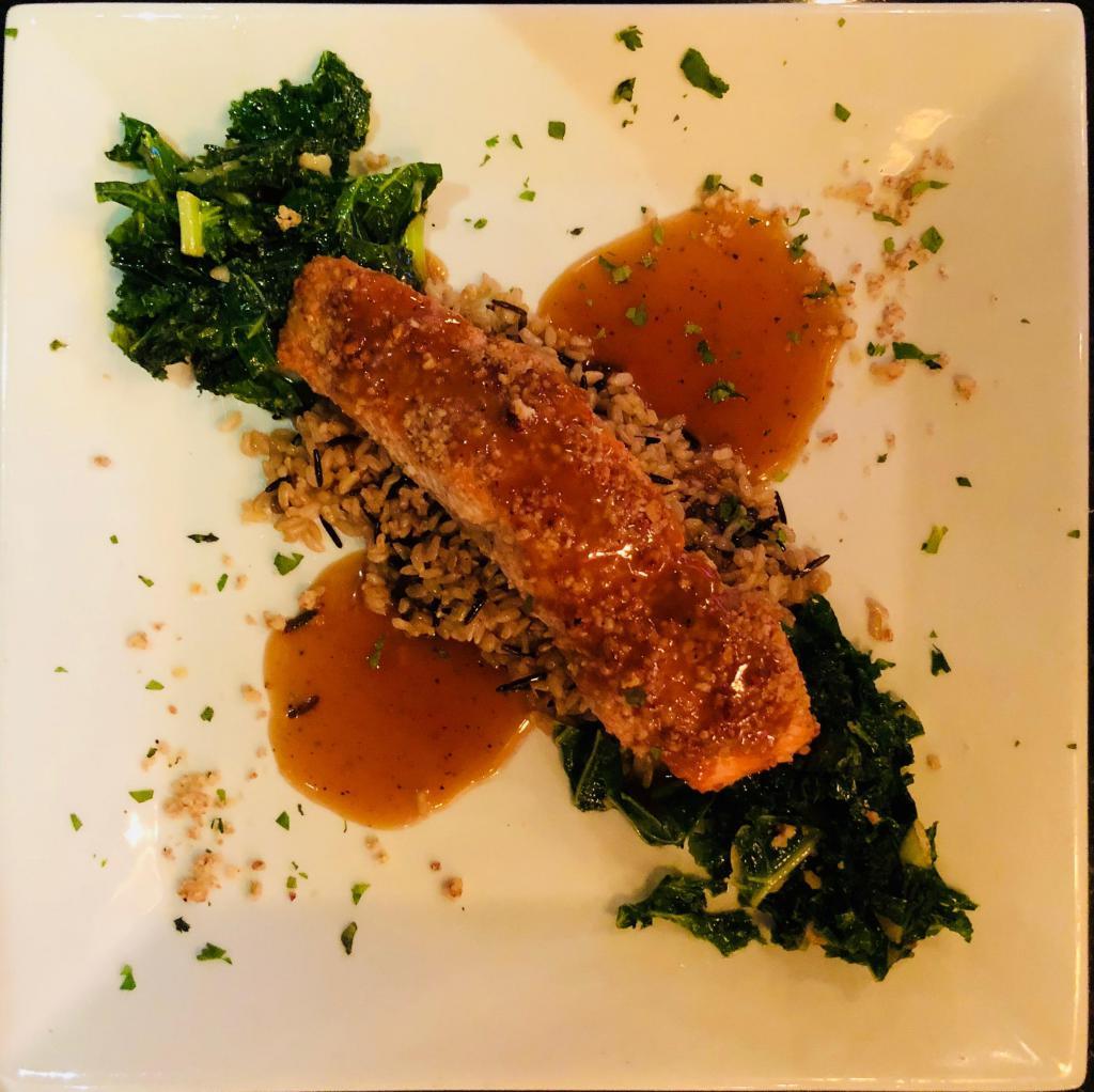 Walnut Crusted Salmon Fillet · Walnut crusted salmon fillet roasted to perfection served over butternut squash risotto and roasted garlic infused kale finished with a maple demi-glace.