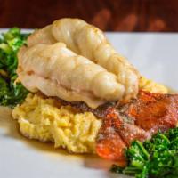 8 oz. Butter Poached Lobster Tail · Served over a creamy goat cheese polenta topped with roasted garlic infused kale finished wi...