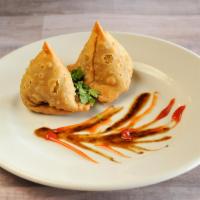 Vegetable Samosa · 2 pieces. Minced potatoes, onions and peas wrapped in pastry dough and fried. Vegetarian.