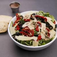 Spinach Salad · Spinach, sun-dried tomatoes, sunflower seeds, capers, olives and Parmesan. Served with choic...