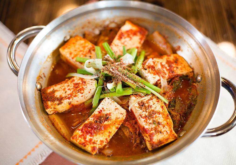 Kimchi Tofu Casserole · Spicy kimchi casserole with tofu, dumplings, and choice of pork or beef. Served with rice.