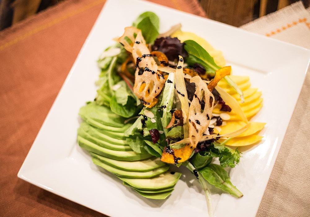 Avocado Mango Salad · Mixed greens, avocado and mango with pineapple-corn dressing, topped with sunflower seeds and lotus root chips. Vegetarian. Gluten free.