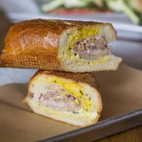 Pork Cubano Sandwich · Roasted mojo pork, pit smoked ham, Swiss, yellow mustard, and pickles on a toasted french ro...