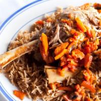 Quabali Palow · Served with basmati rice, carrot, raisins and lamb shank.