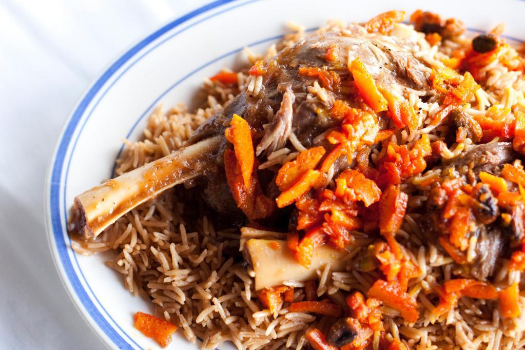 Quabali Palow · Served with basmati rice, carrot, raisins and lamb shank.