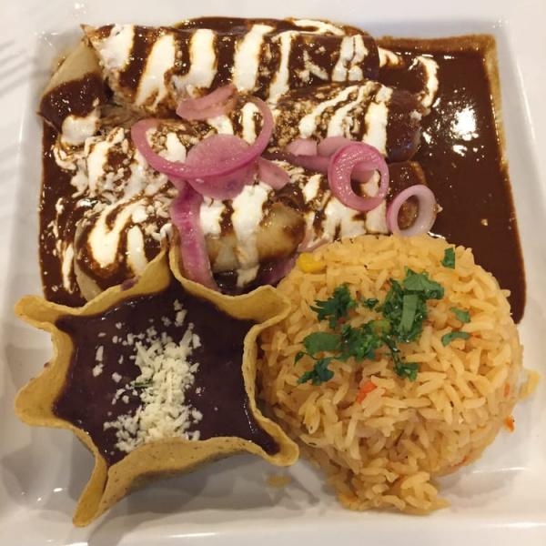 Enchiladas Mole · 3 chicken enchiladas covered in mole poblano topped with sour cream, onions and queso fresco. Served with rice and beans.
