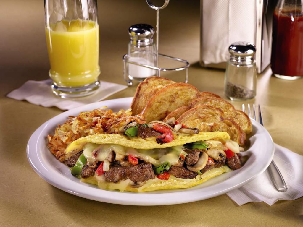 Philly Cheesesteak Omelette · Three-egg omelette with grilled prime rib, fire-roasted bell peppers & onions, sautéed mushrooms, and Swiss cheese. Served with hash browns and choice of bread.