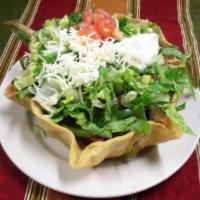 Taco Salad · Crispy flour tortilla bowl filled with your choice of ground beef or chicken, beans, lettuce...