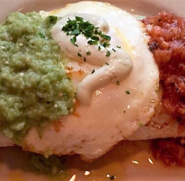 Cochon Burrito · Black beans, pulled pork, cheddar cheese wrapped in a flour tortilla, topped with fried egg, salsa and avocado creme.